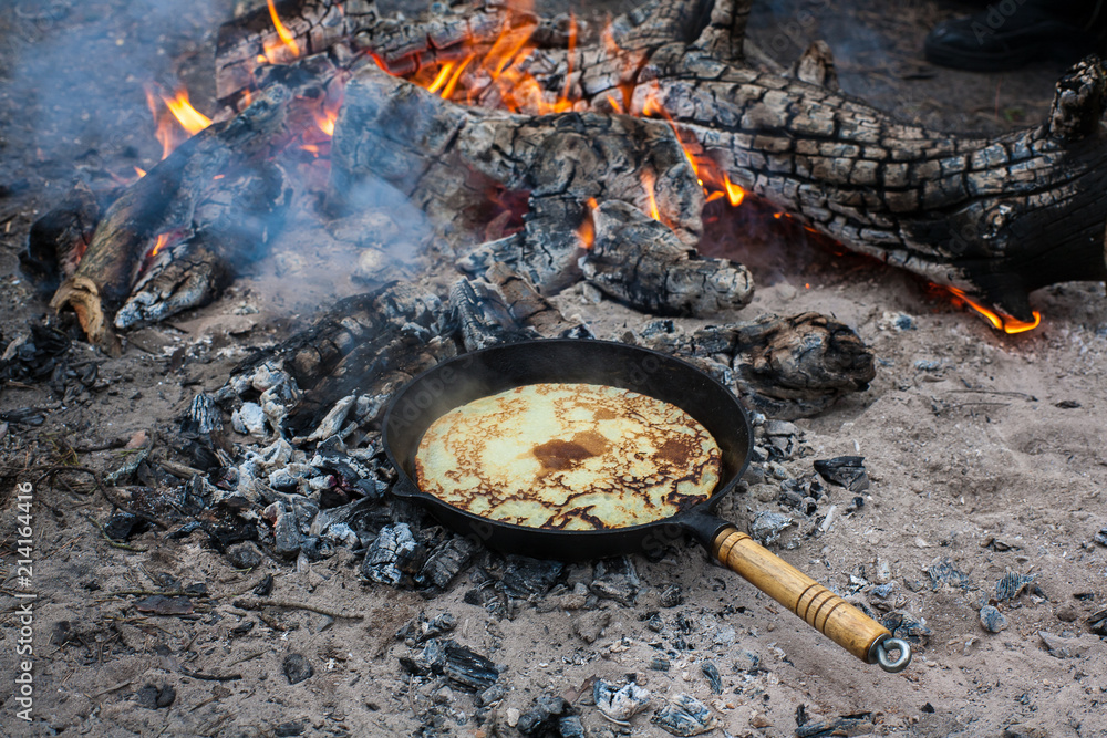 Cooking pancakes on the fire in the forest. Cooking pancakes on the fire in the forest.