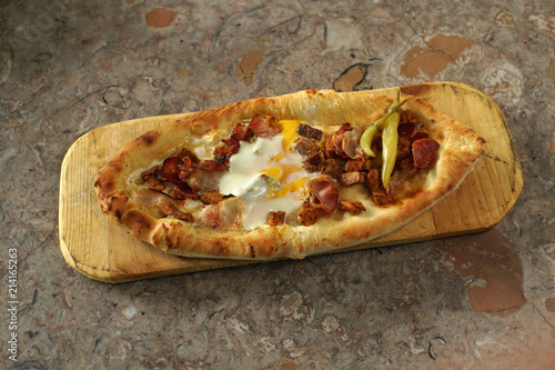 Macedonian pastramajlija dish with hot chilly peppers, pickled, an egg, on a restaurant terrace