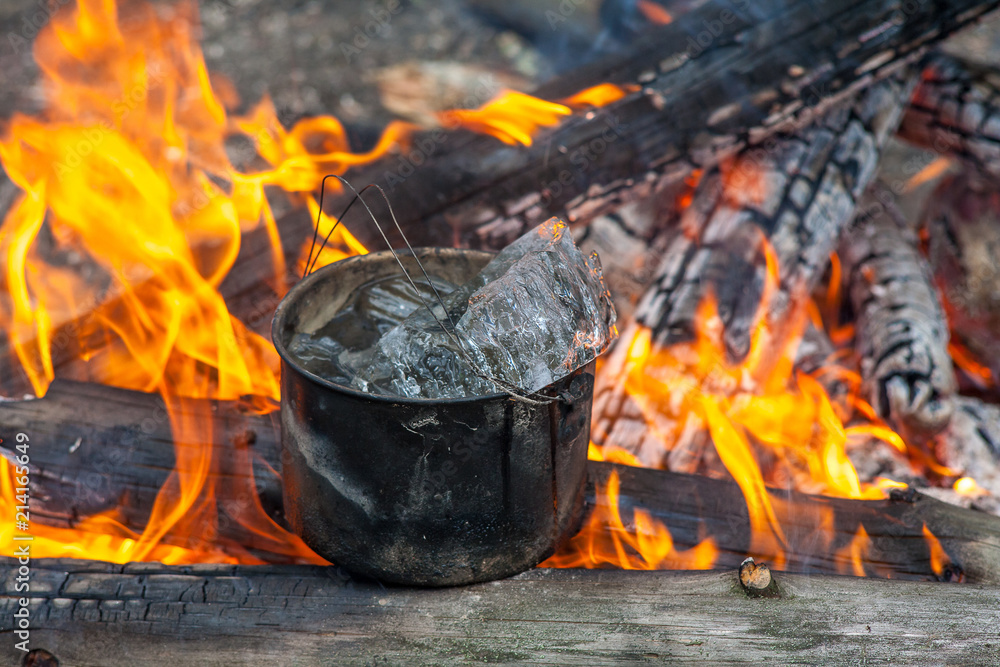 Cooking in the nature. Cauldron with ice on fire in forest. Kitchen in travel. Cooking in the nature. Cauldron with ice on fire in forest. Kitchen in travel.