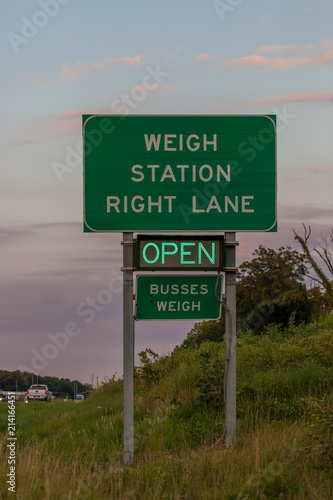 Weigh station sign on Interstate 44 in Oklahoma indicating the scale is open, with evening sky in the background