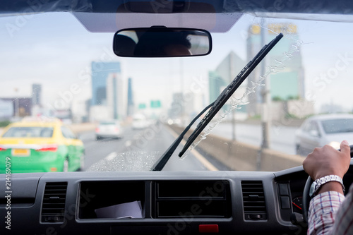 Fotografie Windshield wipers from inside of car, rainy season