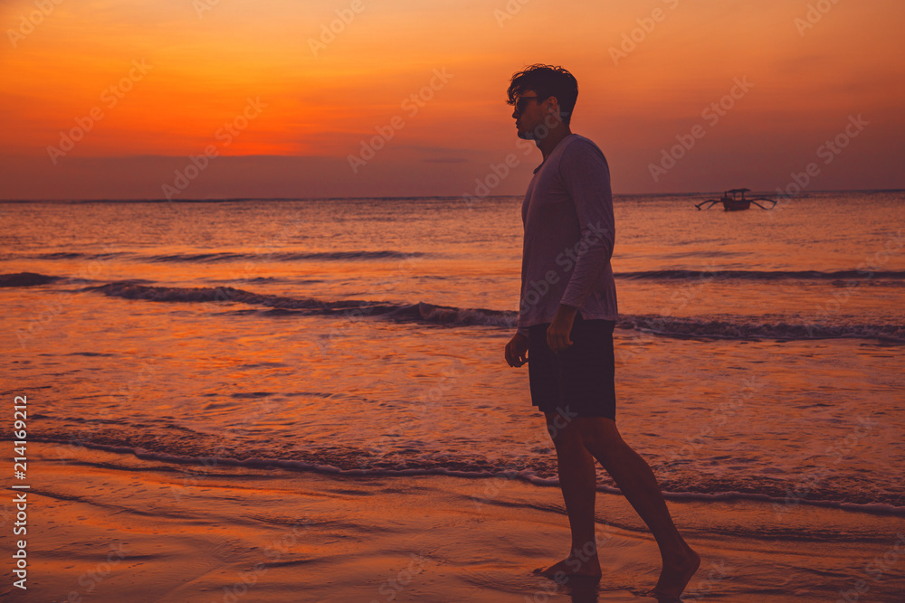Man enjoying on the ocean beach in sunset / sunrise time.