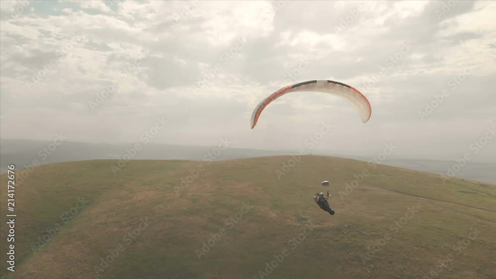 Athlete paraglider flies on his paraglider next to the swallows. Follow-up shooting from the drone Athlete paraglider flies on his paraglider next to the swallows. Follow-up shooting from the drone