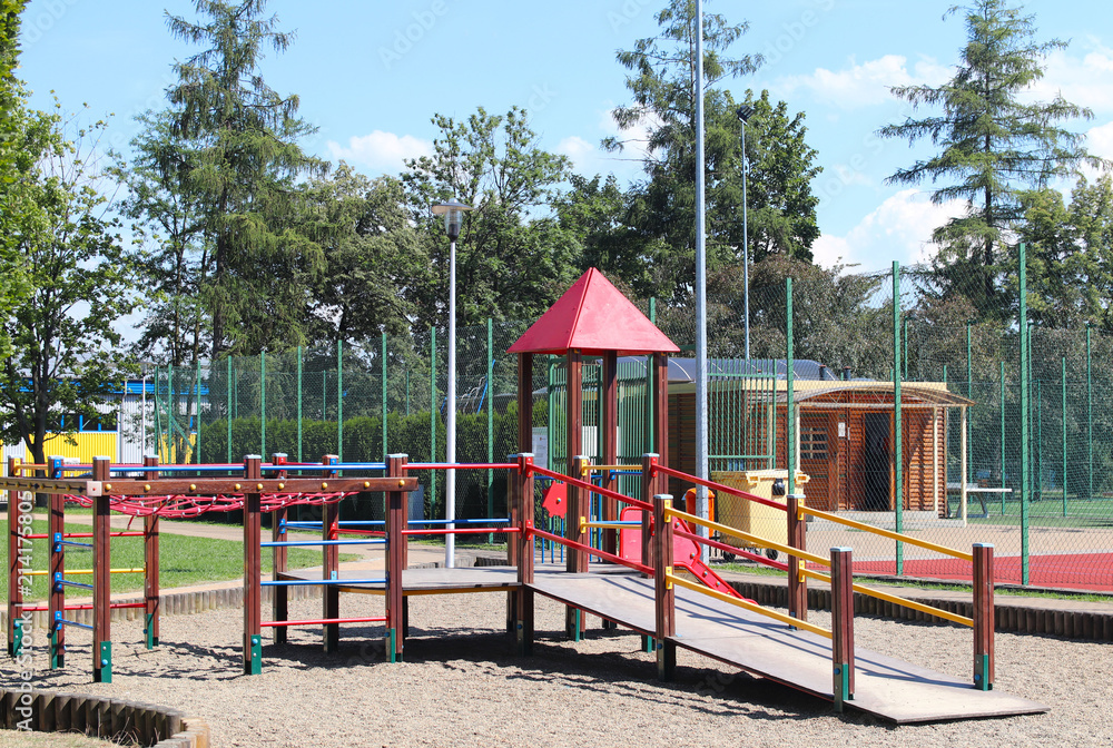 Yaslo, Poland - july 12 2018: Children's playground in the park amidst greenery. Multicolored swings and buildings for children from metal and wood. Place of play of the younger generation. Yaslo, Poland - july 12 2018: Children's playground in the park amidst greenery. Multicolored swings and buildings for children from metal and wood. Place of play of the younger generation.