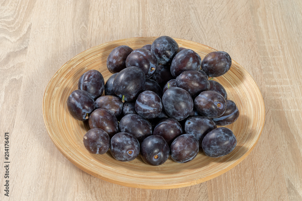 Top view on a wooden basket full of ripe plums Top view on a wooden basket full of ripe plums