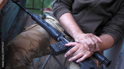 soldier hands and Sniper rifle close up. war.