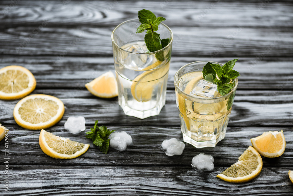 Fototapeta premium white rum.high angle view of glasses with mojito cocktail and ingredients on wooden table.high angle view of glasses with mojito cocktail and ingredients on wooden table.high angle view of glasses wit