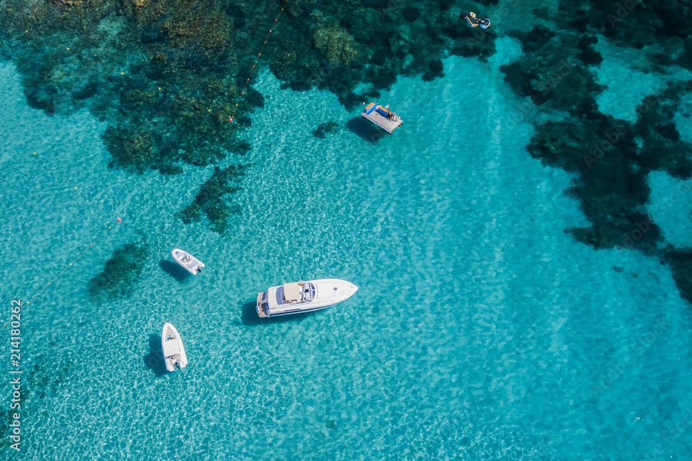 Aerial view of some yachts on an emerald and transparent Mediterranean sea. Emerard coast, Sardinia, Italy.