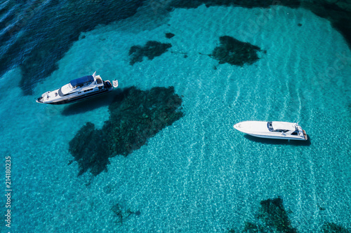 Aerial view of two yachts on an emerald and transparent Mediterranean sea. Emerard coast (Costa Smeralda), Sardinia, Italy. © Travel Wild