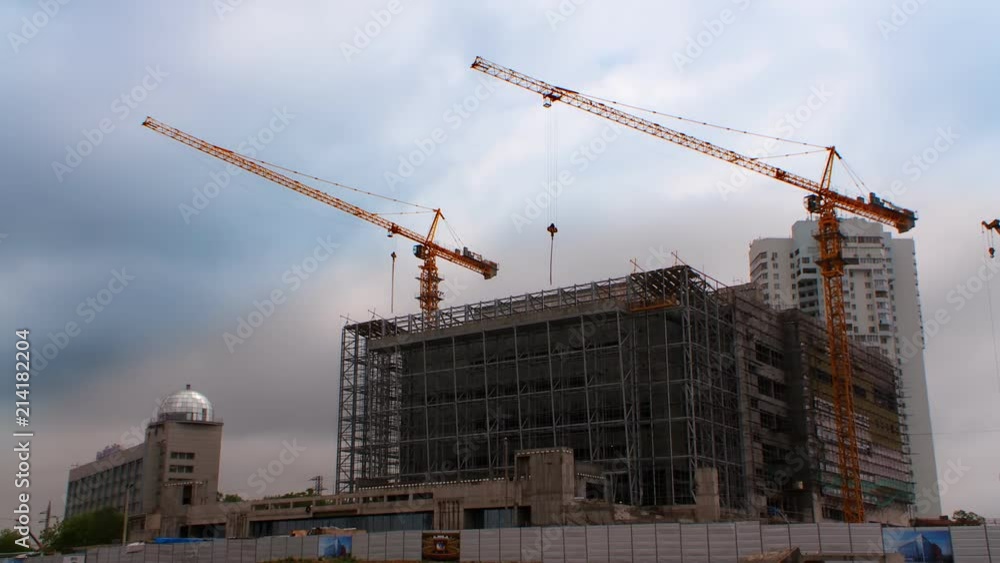 Construction of a building in the city, work of a crane. Scaffolding around the object Construction of a building in the city, work of a crane. Scaffolding around the object