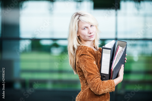 Junge Frau mit Aktenordnern auf dem Arm