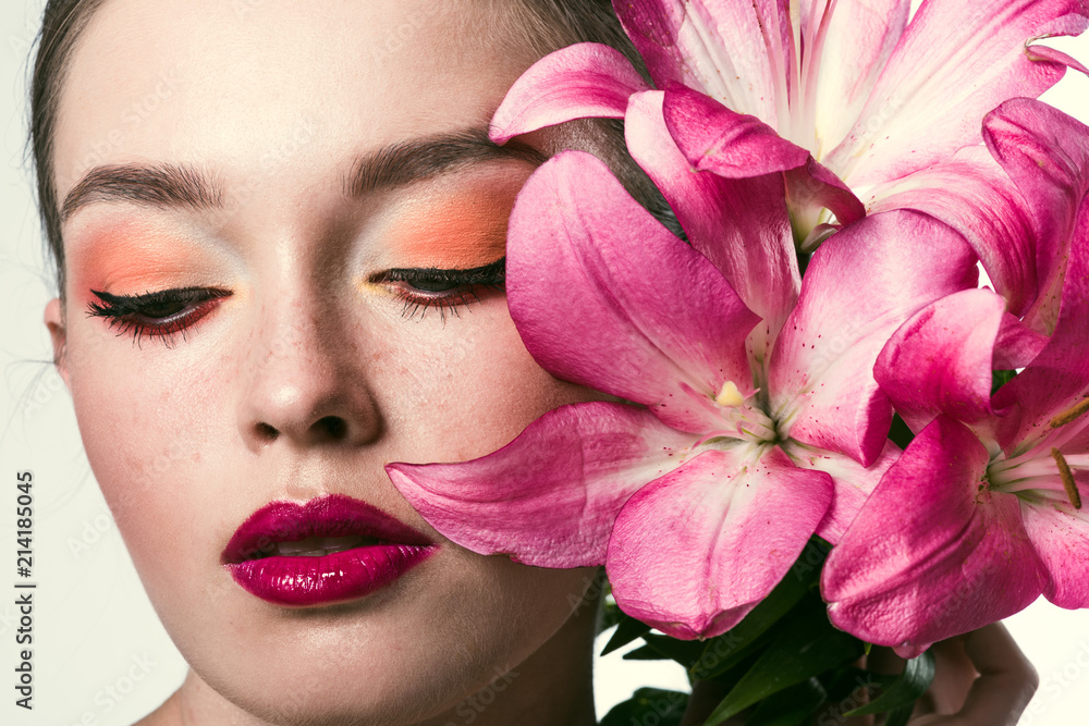close-up portrait of attractive young woman with pink lillies isolated on white close-up portrait of attractive young woman with pink lillies isolated on white