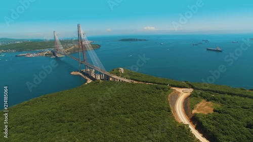 Helicopter ( drone, quadcopter ) flies over the coastal city, the sea and near huge, beautiful cable-stayed bridge. A huge, beautiful cable-stayed bridge with the name 