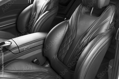 Modern Luxury car inside. Interior of prestige modern car. Comfortable leather seats. Perforated leather with isolated Black background. Modern car interior. Car detailing. Black and white © Aleksei