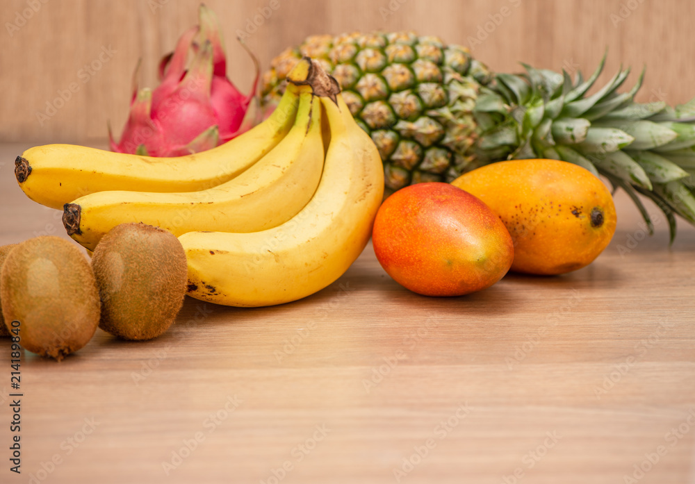 Tropical fresh fruit set and juice smoothies isolated with wooden background Tropical fresh fruit set and juice smoothies isolated with wooden background