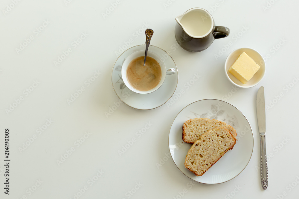 Afternoon tea setting on a white background with banana cake and butter Afternoon tea setting on a white background with banana cake and butter