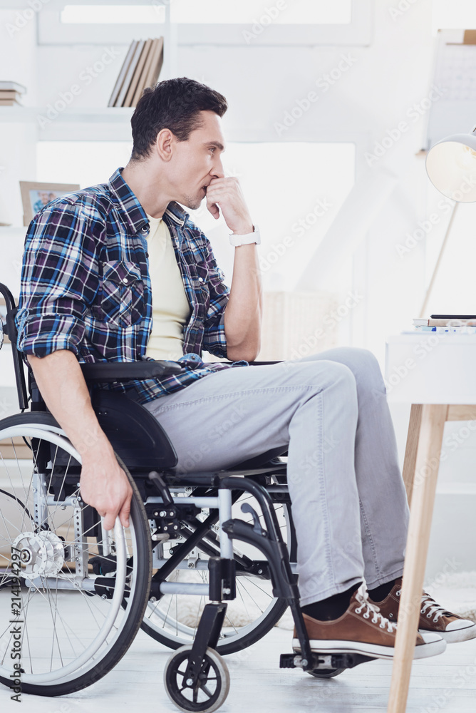 Need inspiration. Handsome man turning head while sitting on his wheelchair Need inspiration. Handsome man turning head while sitting on his wheelchair