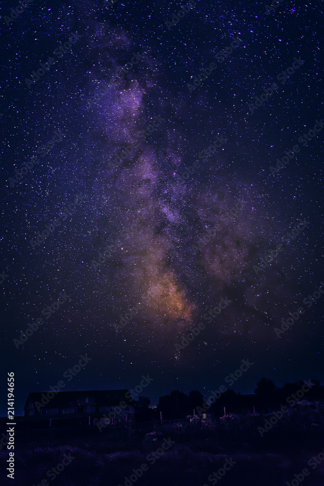 The Milky Way and stars in the night sky over the house and trees. The Milky Way and stars in the night sky over the house and trees.