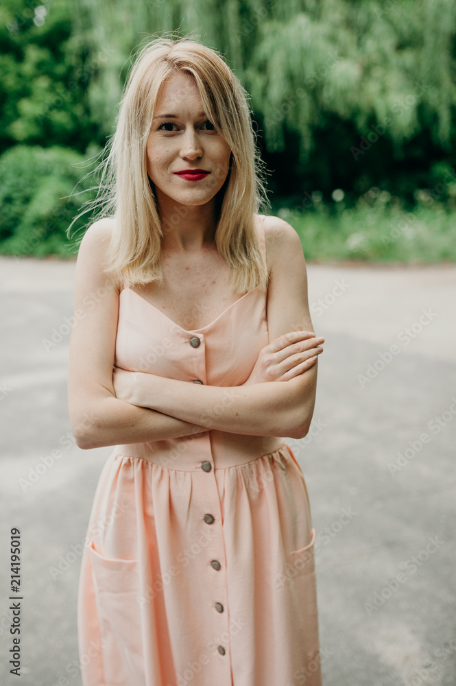 Blondie woman in pink dress in summer forest. Young stylish pretty girl dancing and have fan outdoor, have a good time in park on vacations. Natural, beauty, happiness concept Blondie woman in pink dress in summer forest. Young stylish pretty girl dancing and have fan outdoor, have a good time in park on vacations. Natural, beauty, happiness concept