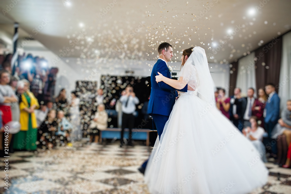 Gorgeous wedding couple performing their first dance with confetti, colorful lights and fireworks.