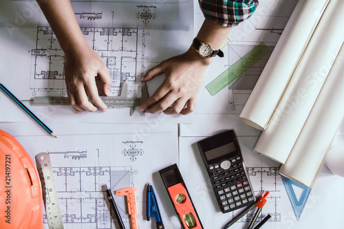 Top view.Concept architects, Hand of asian young  using Vernier caliper equipment architects On the desk with a blueprint in the office. photo