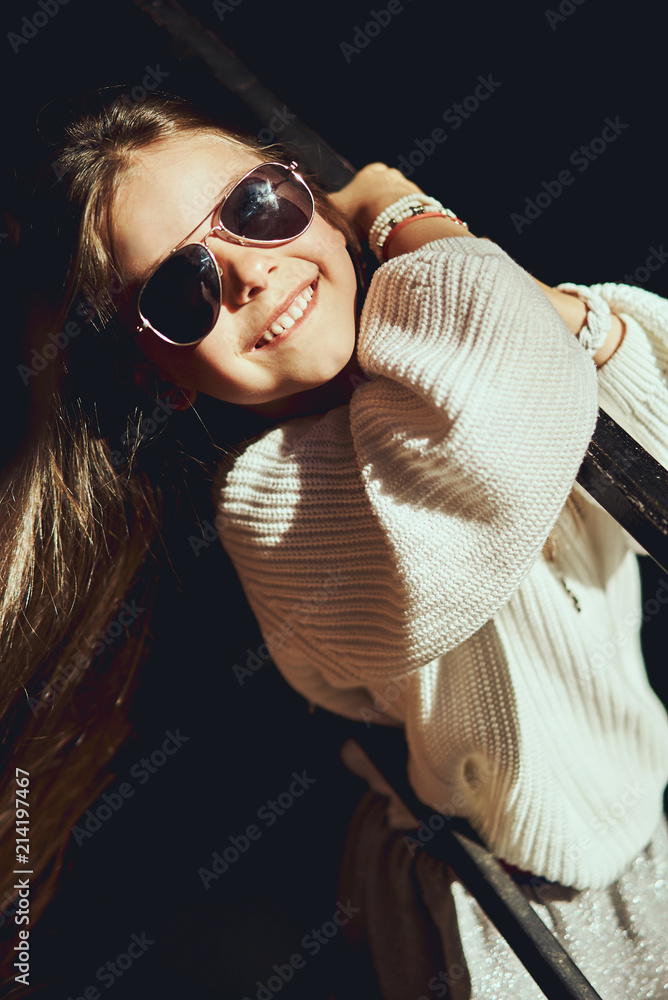 Fototapeta premium Fashion portrait of young girl wearing long dress, tights and modern sneakers shoes