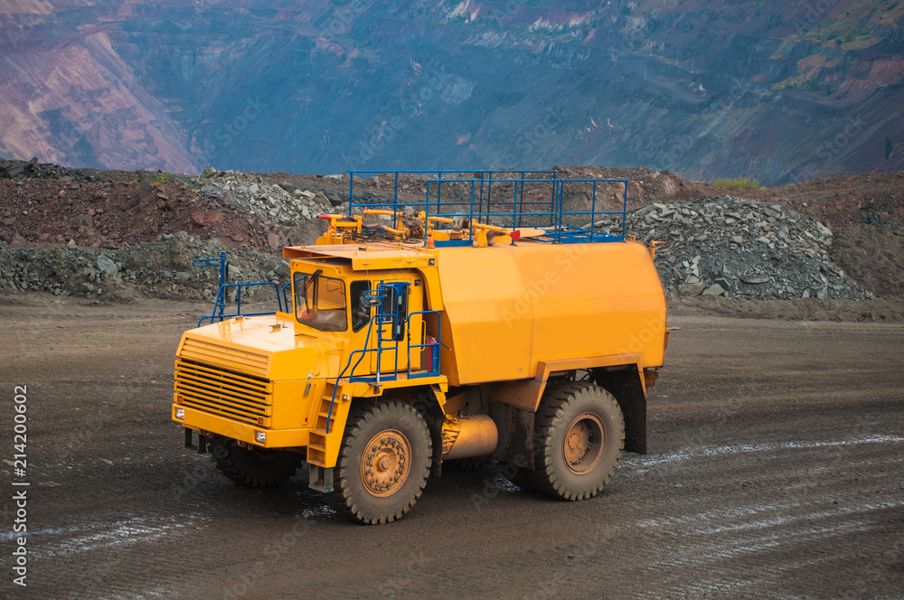 The irrigation machine moves along the road in a career. Dust removal, protection of the environment. Irrigation of the road from dust The irrigation machine moves along the road in a career. Dust removal, protection of the environment. Irrigation of the road from dust