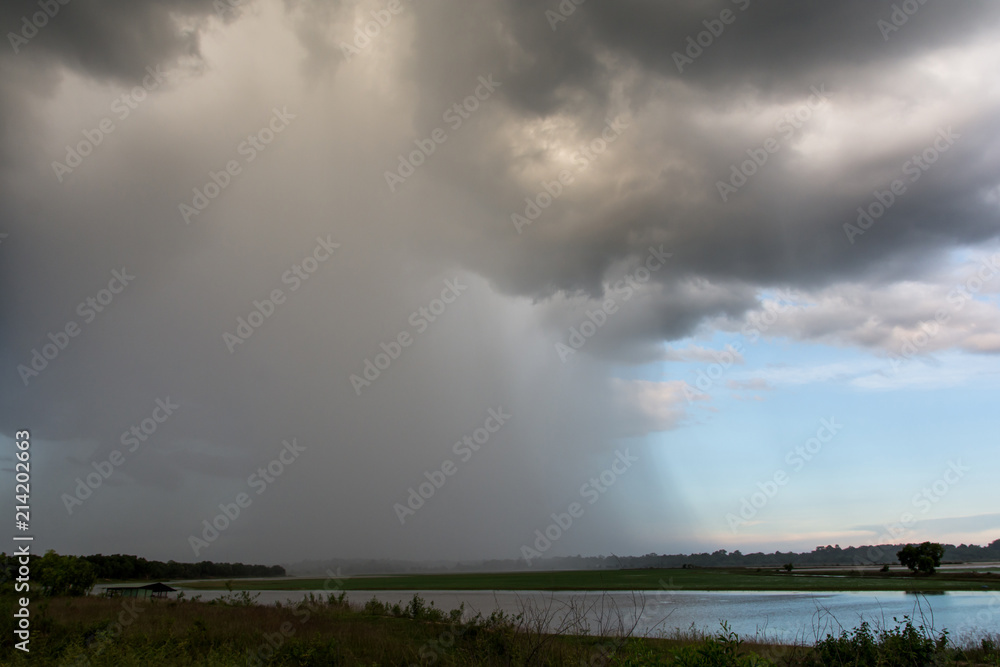 Thunder storm or storm clouds with rain over forest with river Thunder storm or storm clouds with rain over forest with river