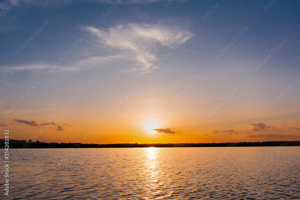 Sunset in the lake. beautiful sunset behind the clouds above the over lake landscape background. dramatic sky with cloud at sunset