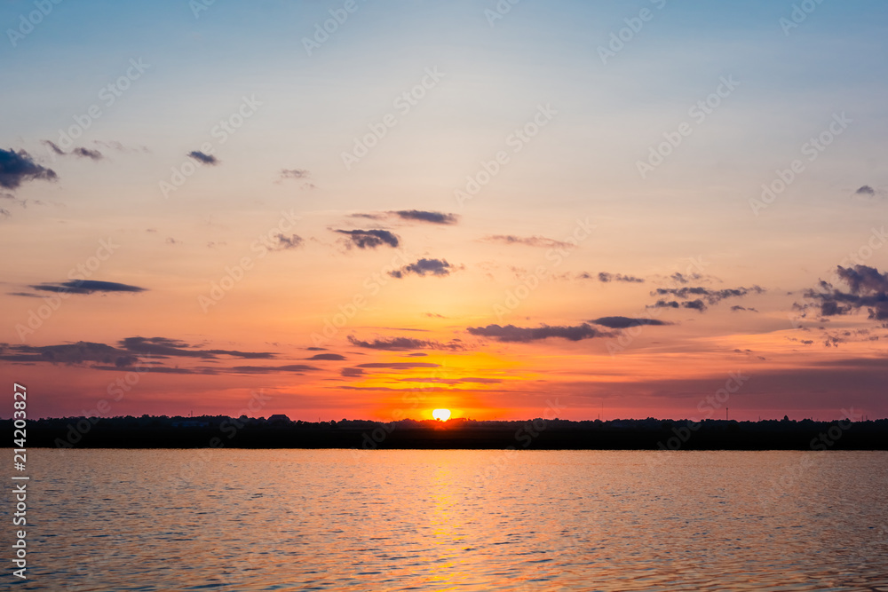 Sunset in the lake. beautiful sunset behind the clouds above the over lake landscape background. dramatic sky with cloud at sunset Sunset in the lake. beautiful sunset behind the clouds above the over lake landscape background. dramatic sky with cloud at sunset