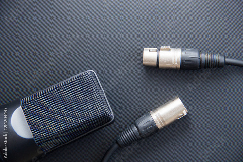Musical equipment, Professional condenser studio microphone with xlr cable, dark color. Close up from above