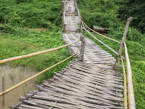 Fototapeta Naklejka Na Ścianę i Meble -  Bamboo pathway in the middle of paddy fields, bamboo walkway and footbridge, wood bridge above field