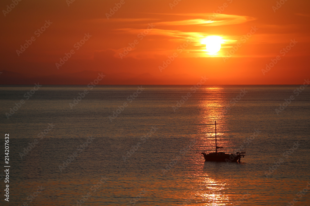 Ship in the sea on the sunrise near the coast