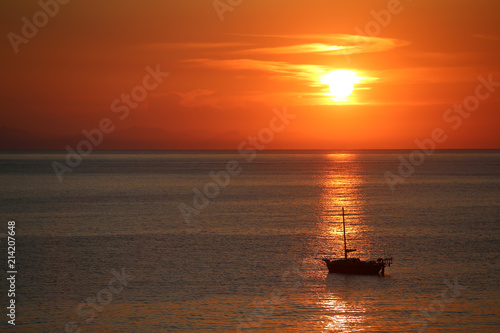 Ship in the sea on the sunrise near the coast