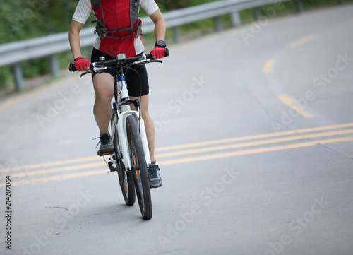 Woman cyclist riding mountain bike on road