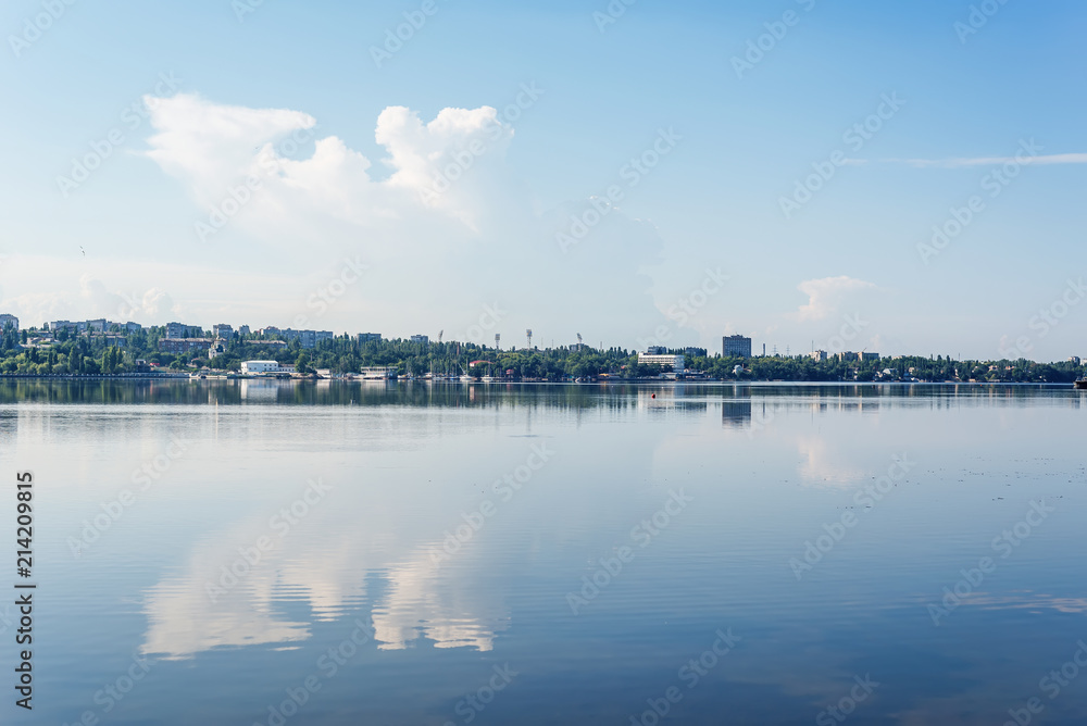 blue sky with clouds and river with reflection of it