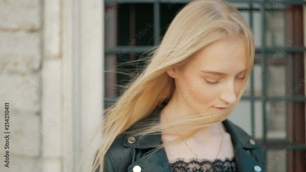 fashion portrait of a beautiful young woman with blue eyes and blonde hair in a leather jacket outdoors fashion portrait of a beautiful young woman with blue eyes and blonde hair in a leather jacket outdoors