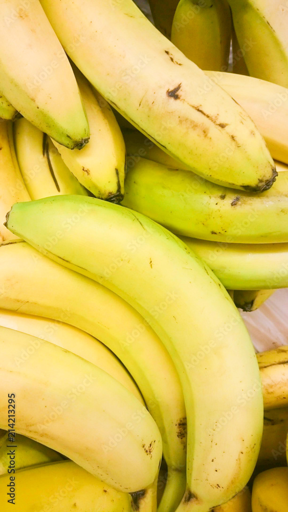 Ripe, yellow bananas lie on the storefront for sale