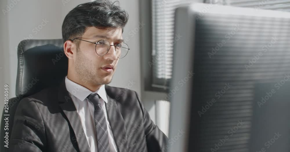 Young turkish businessman working at his computer on project and typing on keyboard, drinking coffee. business concept 4k Young turkish businessman working at his computer on project and typing on keyboard, drinking coffee. business concept 4k