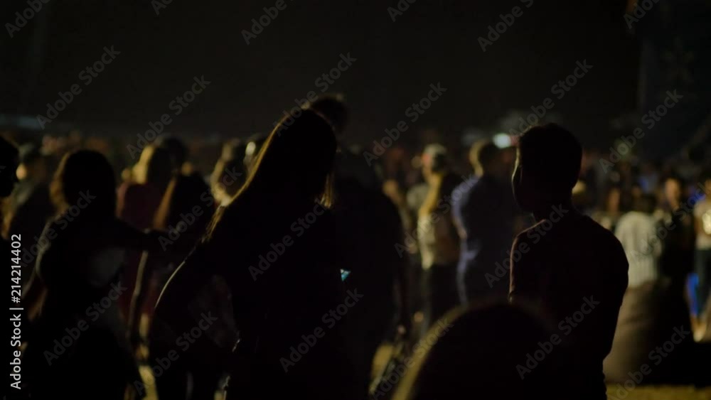 Silhouette of woman and man standing in crowd and waiting at night Silhouette of woman and man standing in crowd and waiting at night