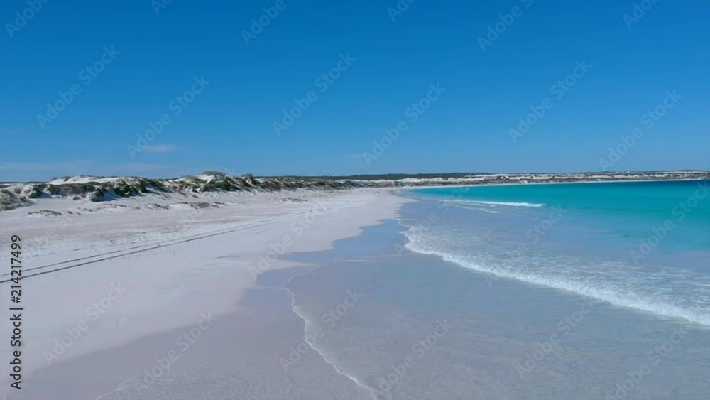 A low dolly shot of a pristine beach setting in summer. A low dolly shot of a pristine beach setting in summer.