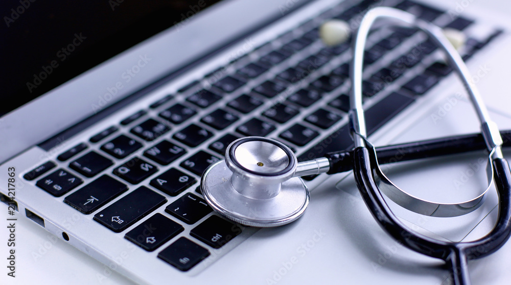 Stethoscope lying on a laptop keyboard in a concept of online m Stethoscope lying on a laptop keyboard in a concept of online m