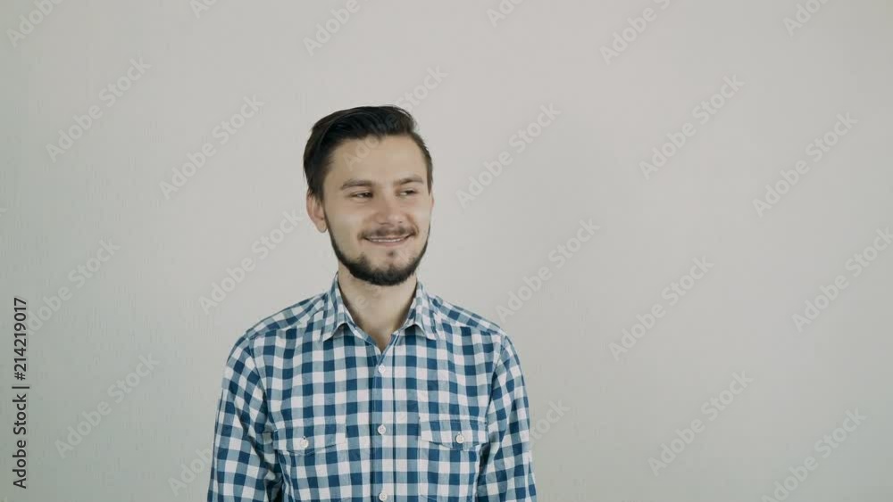 Portrait of happy young bearded man looking to the camera. Man standing against the wall. Portrait of happy young bearded man looking to the camera. Man standing against the wall.