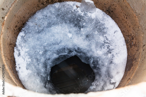 top view of water surface and ice hole in well photo