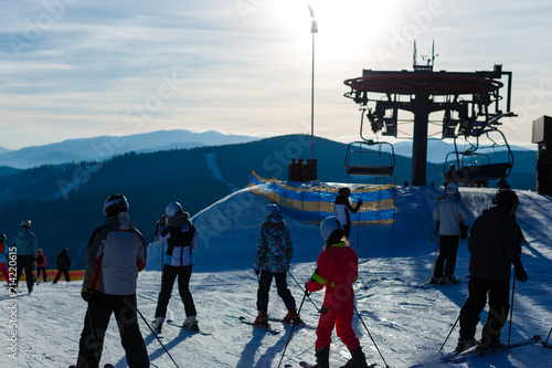 Panoramic view of sport resort for winter vacation - Skies with back light - Warm filter with original sun color tones photo