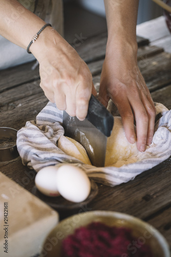 Raw pasta dough in kitchen towel, dough scraper photo