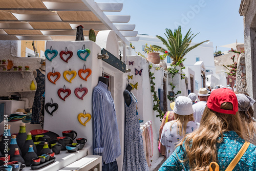 Tourists walk through small shops in the Oia village on the Thira island, Greece.