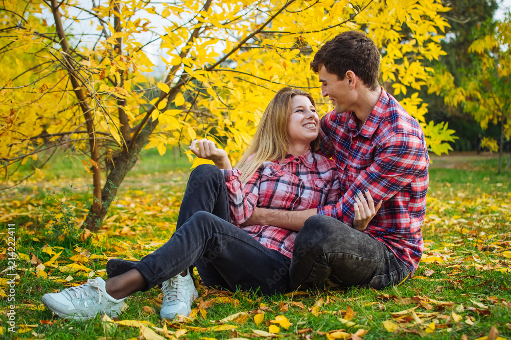Happy young couple having fun and smiling in autumn park outdoors Happy young couple having fun and smiling in autumn park outdoors