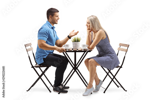 Young man and a young woman sitting at a coffee table and talking