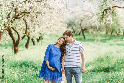 Close up portrait of lovely future parents during sunset on nature apple tree background